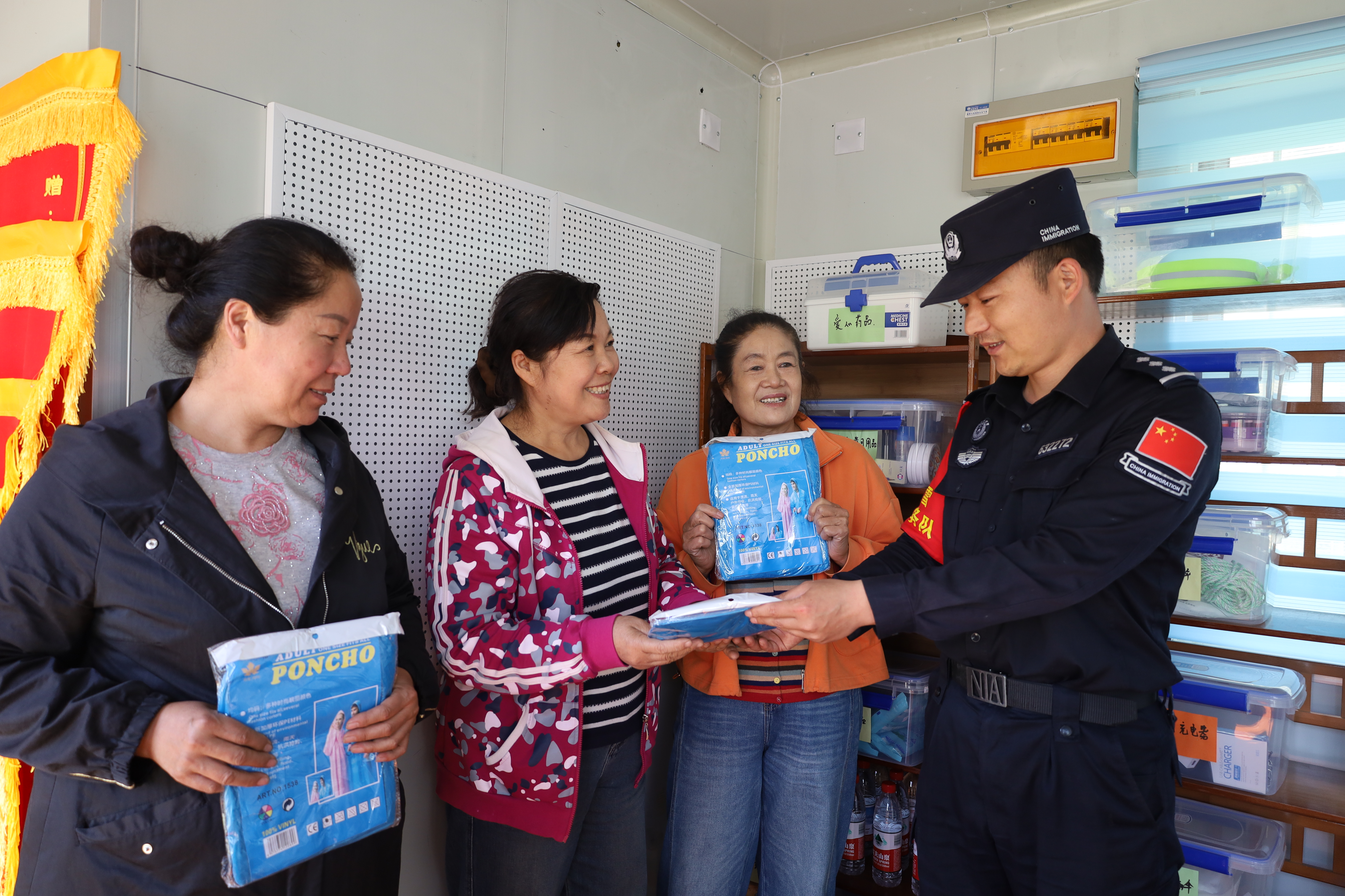 设立于阿克布拉克边境旅游警务驿站的幸福驿站内，游客正领取所需的一次性防雨水衣。